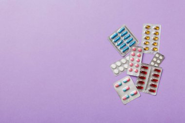 Masa arkasında koruyucu yüz maskeleri, cerrahi maskeler, ilaç hapları ve termometre. Coronavirus hastalığı. Corona virüsü konsepti. Metin için boşluk.