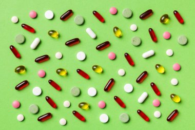 Renkli arka plan ve üst görünüm üzerine yazılmış metinler için birçok farklı hap ve alan. Renkli arka planda farklı haplar, düz yatış.