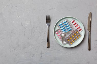 Yuvarlak tabakta yemek olarak birçok farklı kilo kaybı hapı ve takviye maddesi var. Haplar sağlıklı bir yemek olarak sunuldu. Uyuşturucu, eczane, ilaç veya sağlık hizmetleri kavramı.