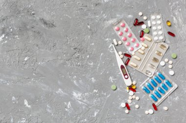 Masa arkasında koruyucu yüz maskeleri, cerrahi maskeler, ilaç hapları ve termometre. Coronavirus hastalığı. Corona virüsü konsepti. Metin için boşluk.