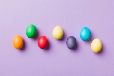 Bayram hazırlığı. Renkli arka planda Paskalya yumurtaları. Pastel renginde Paskalya yumurtası. Kopyalama alanı olan tatil kavramı.