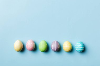 Bayram hazırlığı. Renkli arka planda Paskalya yumurtaları. Pastel renginde Paskalya yumurtası. Kopyalama alanı olan tatil kavramı.