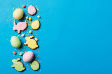 bayram hazırlığı renkli arka planda kurabiyeli çok renkli Paskalya yumurtaları. Pastel renginde Paskalya yumurtası. Kopyalama alanı olan tatil kavramı.