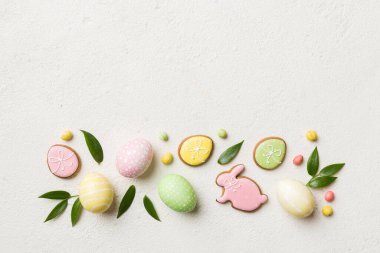 bayram hazırlığı renkli arka planda kurabiyeli çok renkli Paskalya yumurtaları. Pastel renginde Paskalya yumurtası. Kopyalama alanı olan tatil kavramı.
