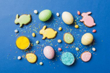 bayram hazırlığı renkli arka planda kurabiyeli çok renkli Paskalya yumurtaları. Pastel renginde Paskalya yumurtası. Kopyalama alanı olan tatil kavramı.