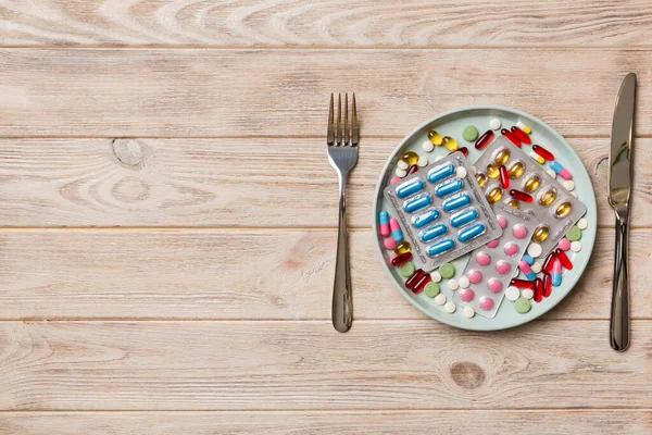 Many different weight loss pills and supplements as food on round plate. Pills served as a healthy meal. Drugs, pharmacy, medicine or medical healthycare concept.