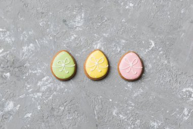 bayram hazırlığı renkli arka planda kurabiyeli çok renkli Paskalya yumurtaları. Pastel renginde Paskalya yumurtası. Kopyalama alanı olan tatil kavramı.