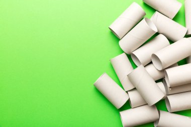 Boş tuvalet kağıdı ruloları ve renk arkaplanı üzerine metin için alanı olan düz bir kompozisyon. Kraft kağıdı veya kartondan yapılmış metal kapaklı geri dönüşümlü kağıt tüp.