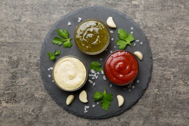 Masada bir sürü farklı sos ve bitki vardı, düz bir manzarası vardı. Tabakta soslar, sağlıklı konsept..