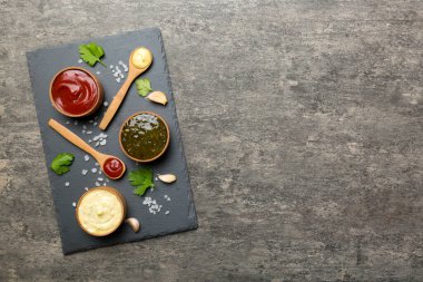 Masada bir sürü farklı sos ve bitki vardı, düz bir manzarası vardı. Tabakta soslar, sağlıklı konsept..