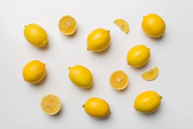 Renkli arka plan olarak pek çok taze limon, üst manzara. Limon ve limon dilimlerinin zarif arka planı Üst görünüm düz yatıyordu.