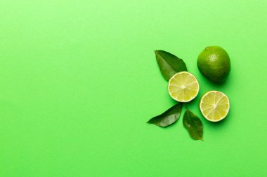 Yeşil yapraklı kireç meyveleri ve beyaz arka planda yarım dilim kesilmiş. Üst Manzara. Kopyalama alanı olan düz.