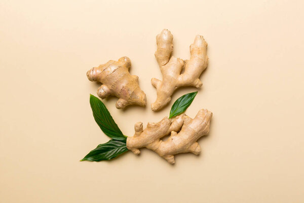 Finely dry Ginger powder in bowl with green leaves isolated on colored background. top view flat lay.