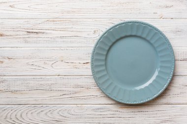 Ahşap zemindeki boş gri tabağın üst görüntüsü. Tasarımın için boş boşluk.