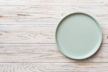 Ahşap zemindeki boş mavi tabağın üst görüntüsü. Tasarımın için boş boşluk.