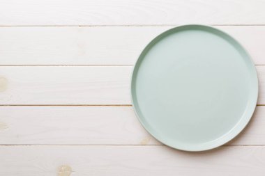 Ahşap zemindeki boş mavi tabağın üst görüntüsü. Tasarımın için boş boşluk.