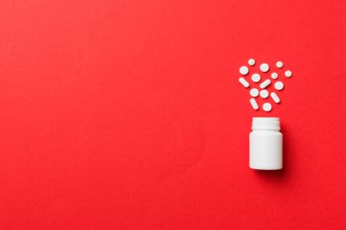 Renkli arka planda plastik şişede çok renkli haplar ve kapsüller, kopyalama alanı. Çeşitli ilaç tabletleri ve haplar, vitamin ve besin takviyeleri kavramı.