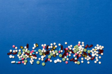 Masa arkasında koruyucu yüz maskeleri, cerrahi maskeler, ilaç hapları ve termometre. Coronavirus hastalığı. Corona virüsü konsepti. Metin için boşluk.