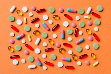 Renkli arka plan ve üst görünüm üzerine yazılmış metinler için birçok farklı hap ve alan. Renkli arka planda farklı haplar, düz yatış.