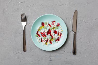 Yuvarlak tabakta yemek olarak birçok farklı kilo kaybı hapı ve takviye maddesi var. Haplar sağlıklı bir yemek olarak sunuldu. Uyuşturucu, eczane, ilaç veya sağlık hizmetleri kavramı.