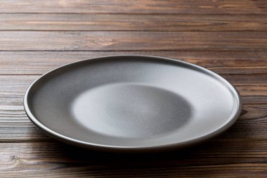 Ahşap zemindeki boş siyah plakanın perspektif görüntüsü. Tasarımın için boş boşluk.