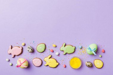 bayram hazırlığı renkli arka planda kurabiyeli çok renkli Paskalya yumurtaları. Pastel renginde Paskalya yumurtası. Kopyalama alanı olan tatil kavramı.
