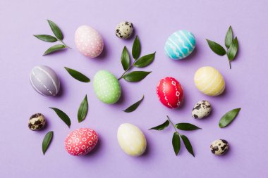 Beyaz arka planda yay yaprağı olan renkli Paskalya yumurtaları. Renkli Yumurta Tatil Kenarı.