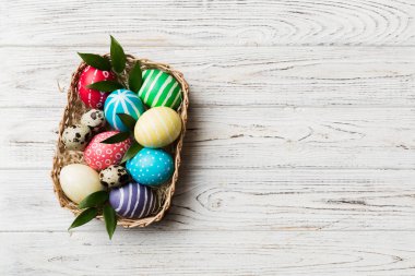 Renkli arka planda dokuma sepetinde çok renkli Paskalya yumurtaları. Pastel renginde Paskalya yumurtası. Kopyalama alanı olan tatil kavramı.