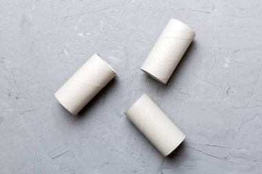 Boş tuvalet kağıdı ruloları ve renk arkaplanı üzerine metin için alanı olan düz bir kompozisyon. Kraft kağıdı veya kartondan yapılmış metal kapaklı geri dönüşümlü kağıt tüp.