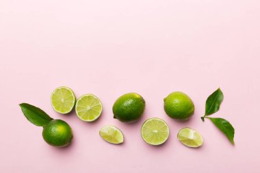 Yeşil yapraklı kireç meyveleri ve beyaz arka planda yarım dilim kesilmiş. Üst Manzara. Kopyalama alanı olan düz.
