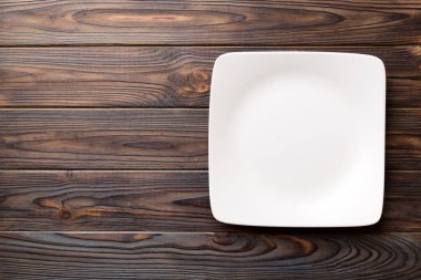 Ahşap zemin üzerinde boş kare plakanın üst görünümü. Tasarımın için boş boşluk.