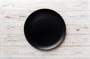 Ahşap arka plandaki siyah plakanın üst görüntüsü. Tasarımın için boş boşluk.