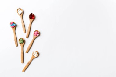 Renkli arka planda tahta kaşıkta vitamin ve mineral haplarının üst görünümü. Muhtelif ilaç haplarının en üst görüntüsü. Beslenme takviyesi sağlık ürünleri.