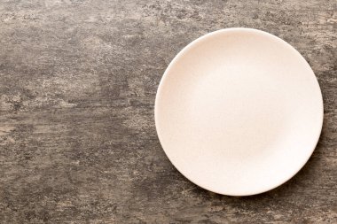 Ahşap zemindeki boş renkli tabağın üst görünümü. Tasarımın için boş boşluk.