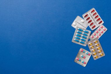 Masa arkasında koruyucu yüz maskeleri, cerrahi maskeler, ilaç hapları ve termometre. Coronavirus hastalığı. Corona virüsü konsepti. Metin için boşluk.