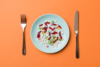 Yuvarlak tabakta yemek olarak birçok farklı kilo kaybı hapı ve takviye maddesi var. Haplar sağlıklı bir yemek olarak sunuldu. Uyuşturucu, eczane, ilaç veya sağlık hizmetleri kavramı.