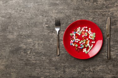 Yuvarlak tabakta yemek olarak birçok farklı kilo kaybı hapı ve takviye maddesi var. Haplar sağlıklı bir yemek olarak sunuldu. Uyuşturucu, eczane, ilaç veya sağlık hizmetleri kavramı.