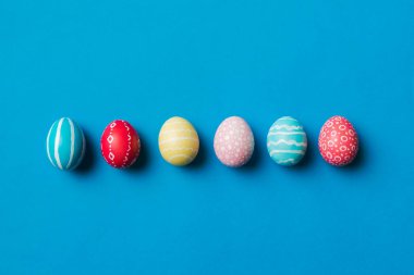 Bayram hazırlığı. Renkli arka planda Paskalya yumurtaları. Pastel renginde Paskalya yumurtası. Kopyalama alanı olan tatil kavramı.