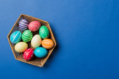 Renkli arka planda dokuma sepetinde çok renkli Paskalya yumurtaları. Pastel renginde Paskalya yumurtası. Kopyalama alanı olan tatil kavramı.