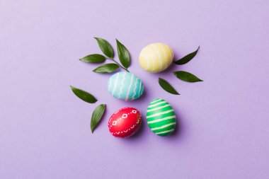 Beyaz arka planda yay yaprağı olan renkli Paskalya yumurtaları. Renkli Yumurta Tatil Kenarı.