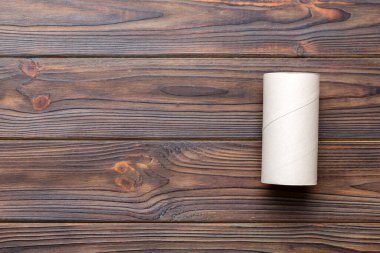 Boş tuvalet kağıdı ruloları ve renk arkaplanı üzerine metin için alanı olan düz bir kompozisyon. Kraft kağıdı veya kartondan yapılmış metal kapaklı geri dönüşümlü kağıt tüp.