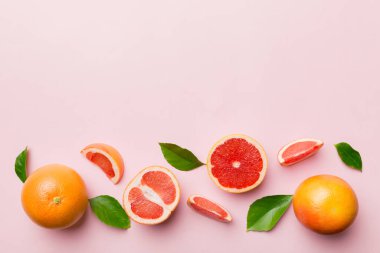 Renkli arka planda sulu greyfurt dilimli taze meyve greyfurdu. Üst Manzara. Uzayı kopyala yaratıcı yaz konsepti. Minimum düzlükte turunçgillerin yarısı kopyalama alanı ile yatar.