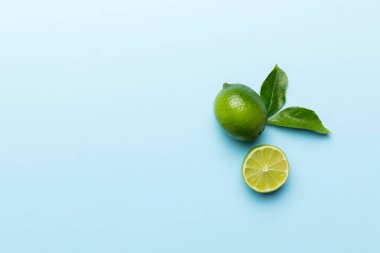 Yeşil yapraklı kireç meyveleri ve beyaz arka planda yarım dilim kesilmiş. Üst Manzara. Kopyalama alanı olan düz.