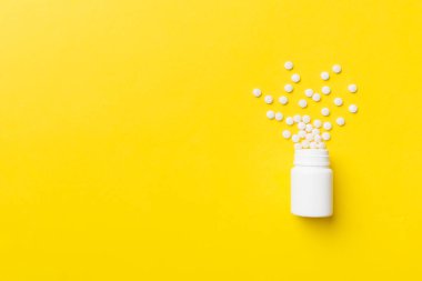 Renkli arka planda plastik şişede çok renkli haplar ve kapsüller, kopyalama alanı. Çeşitli ilaç tabletleri ve haplar, vitamin ve besin takviyeleri kavramı.