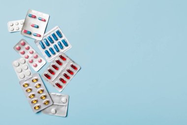 Masa arkasında koruyucu yüz maskeleri, cerrahi maskeler, ilaç hapları ve termometre. Coronavirus hastalığı. Corona virüsü konsepti. Metin için boşluk.