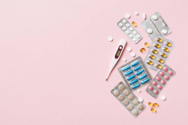 Masa arkasında koruyucu yüz maskeleri, cerrahi maskeler, ilaç hapları ve termometre. Coronavirus hastalığı. Corona virüsü konsepti. Metin için boşluk.