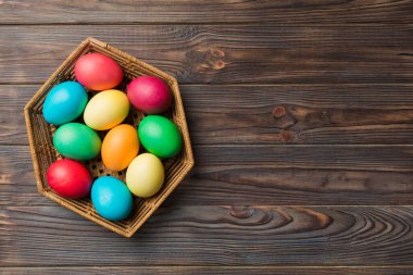 Renkli arka planda dokuma sepetinde çok renkli Paskalya yumurtaları. Pastel renginde Paskalya yumurtası. Kopyalama alanı olan tatil kavramı.