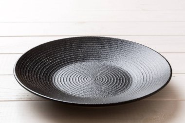 Ahşap zemindeki boş siyah plakanın perspektif görüntüsü. Tasarımın için boş boşluk.