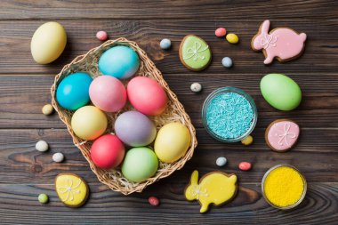 Renkli paskalya kurabiyeleri sepette renkli arka planda çok renkli Paskalya yumurtaları. Pastel renginde Paskalya yumurtası. Kopyalama alanı olan tatil kavramı.
