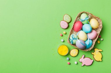 Renkli paskalya kurabiyeleri sepette renkli arka planda çok renkli Paskalya yumurtaları. Pastel renginde Paskalya yumurtası. Kopyalama alanı olan tatil kavramı.
